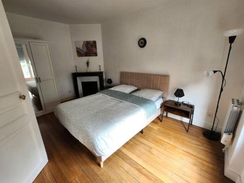 - une chambre avec un grand lit et une cheminée dans l'établissement Cosy T2 proche Basilique Saint Denis, à Saint-Denis