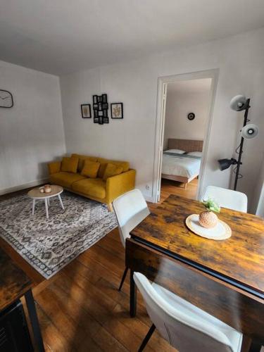 un salon avec une table et un canapé dans l'établissement Cosy T2 proche Basilique Saint Denis, à Saint-Denis