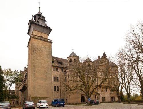 an old building with a clock tower in front of it at Neben der Kirche in Neuenstein