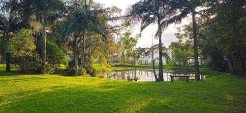 a park with a pond with palm trees and a pond at Cabana Du Sítio in Praia Grande