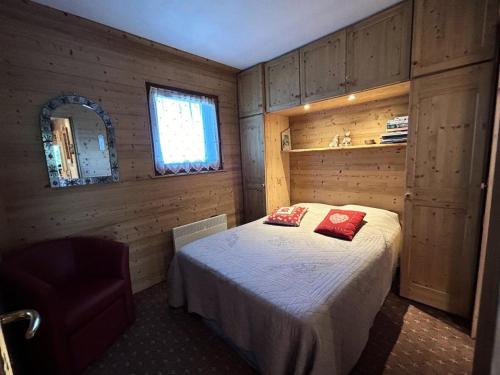 une chambre avec un lit dans une pièce aux murs en bois dans l'établissement Résidence Erines - ERINES 17B MAE-6401, à Les Allues