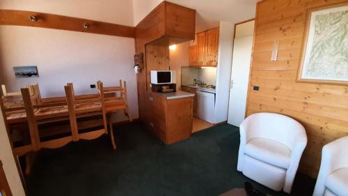 une cuisine et une salle à manger avec une table et des chaises dans l'établissement Résidence Creux De L Ours A - CREUX DE L'OURS A54 MAE-6361, à Les Allues