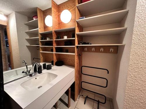 La salle de bains est pourvue d'un lavabo et d'un comptoir avec des étagères. dans l'établissement Résidence Candide - CANDIDE B20 MAE-6381, à Les Allues