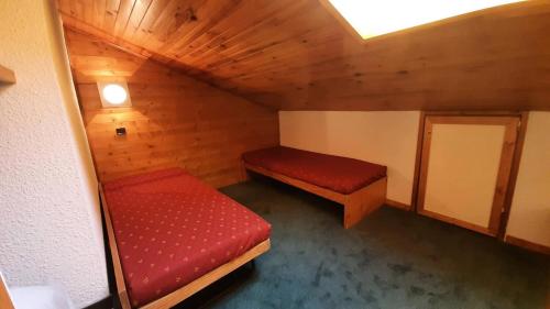 - une petite chambre avec 2 lits rouges dans une cabine dans l'établissement Résidence Creux De L Ours A - CREUX DE L'OURS A54 MAE-6361, à Les Allues