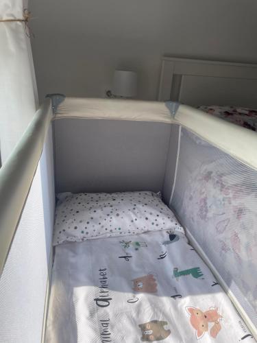 a childs crib with a mattress with animals on it at Apartman L, SELF CHECK IN, FREE PARKING in Karlovac