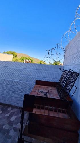 a wooden bench sitting next to a wall at Estadía temporal in Quebrada de los Códores