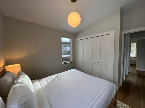 a bedroom with a large white bed and a window at 4595 Alpine Way by StayIn in Fernie