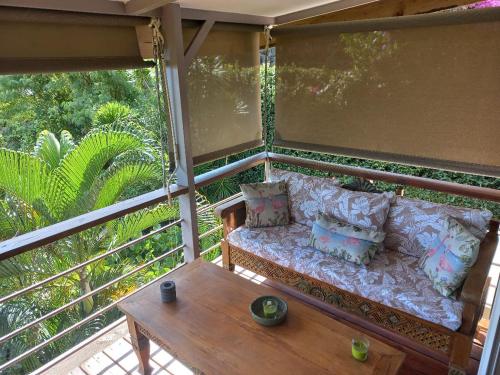 a porch with a couch and a coffee table at MARINA BLUE fabuleux Appartement vue LAGON in Punaauia
