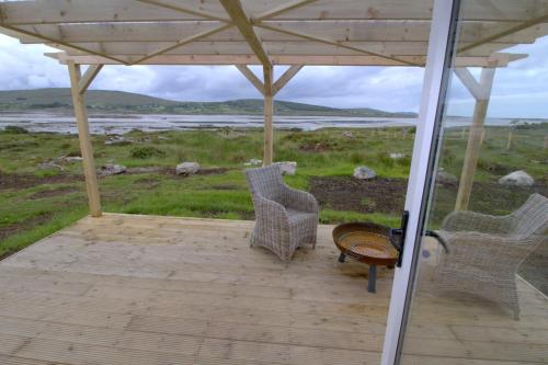 two chairs and a table on a porch with a view at The Oyster House in Dungloe