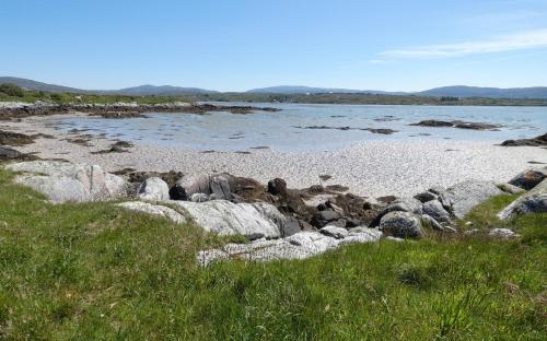 a beach with rocks and a body of water at The Oyster House in Dungloe