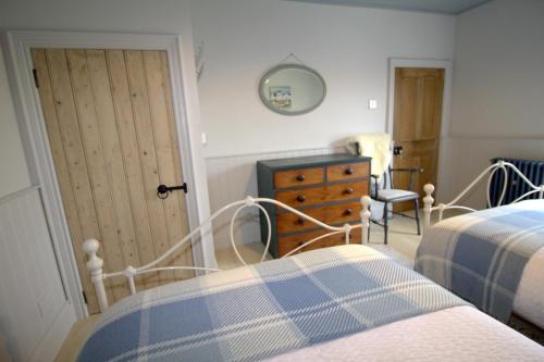 a bedroom with a bed and a dresser and a door at The Oyster House in Dungloe