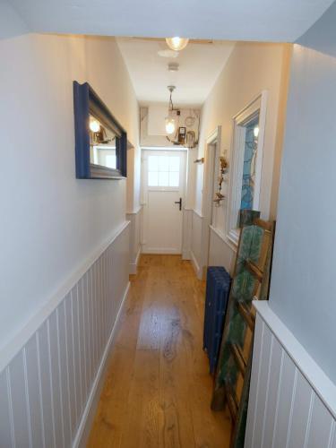 a hallway with white walls and a wooden floor at The Oyster House in Dungloe