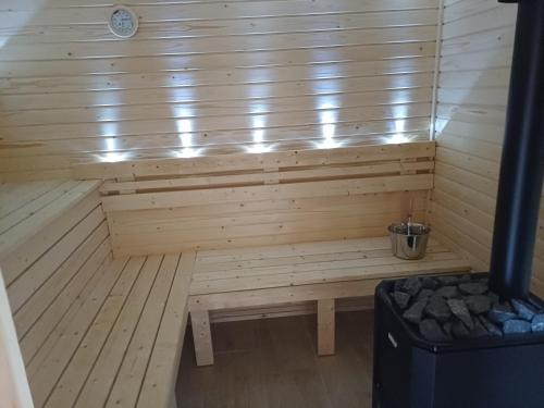 a wooden sauna with a bench in a room at Benige vendégház in Demjén