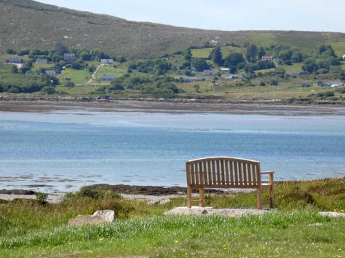 a bench sitting on a hill overlooking a body of water at The Oyster House in Dungloe