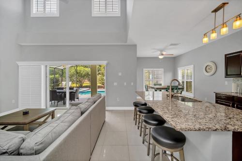 a kitchen and living room with a couch and a table at Completely Remodeled 5 Bedroom Disney Pool Home in Davenport