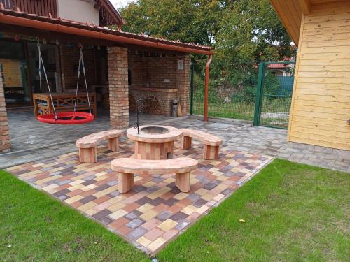a patio with a picnic table and a swing at Benige vendégház in Demjén