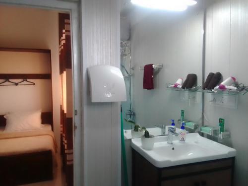 a bathroom with a sink and a mirror and a bed at Kandy Home stay in Katugastota
