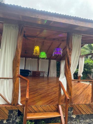 a wooden deck with two chairs and two chandeliers at Parti Gras Hotel & Villas en Playa Potrero in Potrero