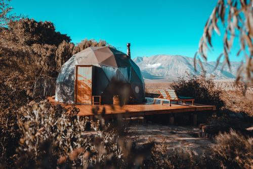 a yurt with a bench on a wooden deck at Domos Uspallata in Uspallata