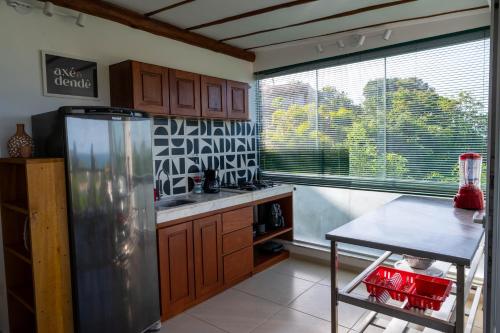 a kitchen with a refrigerator and a table and a window at Casa MiMa com vista maravilhosa in Morro de São Paulo