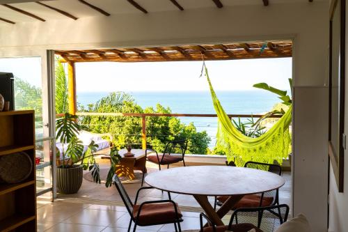 a room with a balcony with a table and chairs at Casa MiMa com vista maravilhosa in Morro de São Paulo