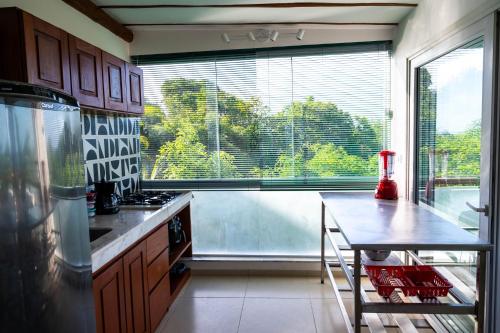 a kitchen with a table and a large window at Casa MiMa com vista maravilhosa in Morro de São Paulo