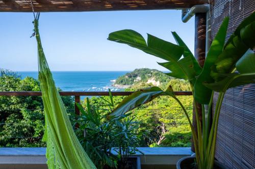 a view of the ocean from a balcony with a hammock at Casa MiMa com vista maravilhosa in Morro de São Paulo