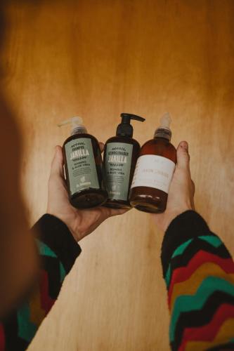 a person holding three bottles of soap in their hands at Domos Uspallata in Uspallata