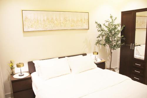 リヤドにあるرايا 03 raya القماريの白いベッドと鏡のある寝室