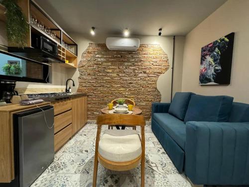 a living room with a blue couch and a kitchen at Casa Di Tatiana in Valledupar