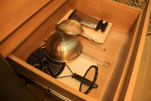 a metal tea pot and tongs in a drawer at Casa Di Tatiana in Valledupar