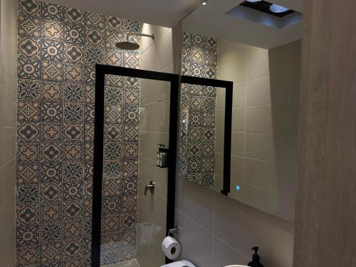 a bathroom with a shower with a toilet and a mirror at Casa Di Tatiana in Valledupar