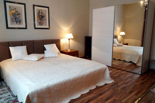 a bedroom with a large white bed and a mirror at Vip Apartment an den Thermen in Baden-Baden
