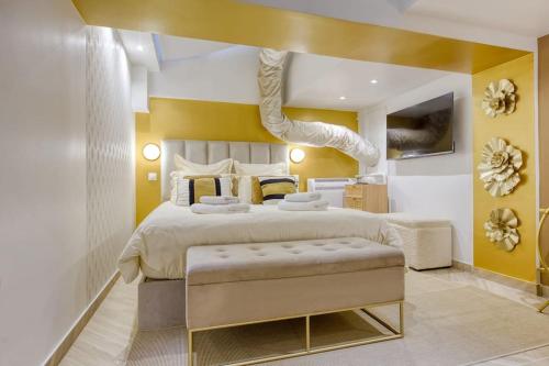 - une chambre avec un grand lit aux murs jaunes dans l'établissement Élysée Prestige, à Paris