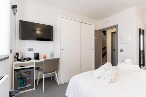 a white bedroom with a desk and a bed at Barighouse in Ulassai