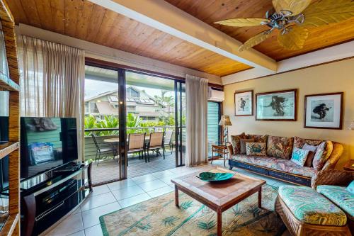a living room with a couch and a tv at Kahana Outrigger 1A1 in Kahana