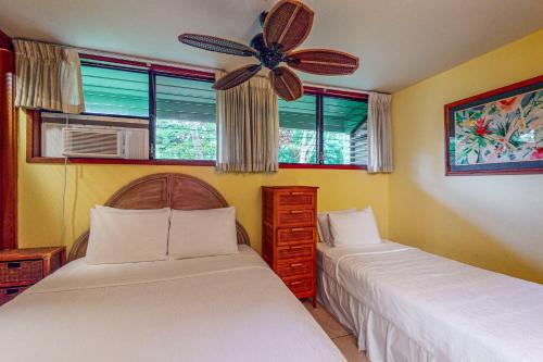 a bedroom with two beds and a ceiling fan at Kahana Outrigger 1A1 in Kahana