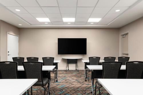 a conference room with tables and chairs and a flat screen tv at Residence Inn by Marriott Kingston in Kingston