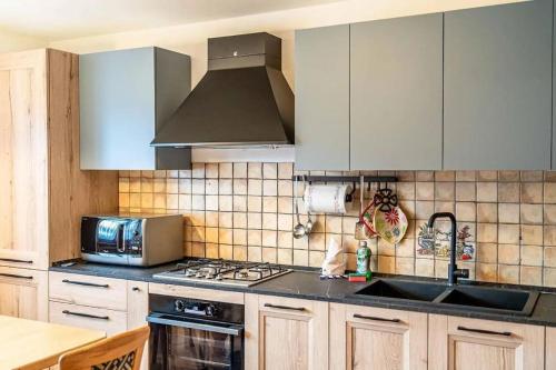 a kitchen with a sink and a stove top oven at Casa di Sere in Pieve di Livinallongo