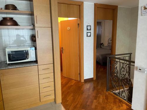Una cocina con microondas y una puerta a una habitación. en Da NOEMI E MARCO, en Cavalese