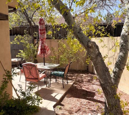 a patio with a table and chairs and a tree at Randy's Roost in Santa Fe