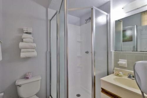 a bathroom with a shower and a toilet and a sink at Coastal Waters in New Smyrna Beach