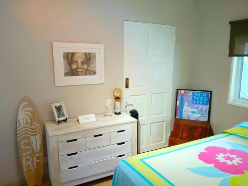 a bedroom with a bed and a dresser and a drawer at MARINA BLUE fabuleux Appartement vue LAGON in Punaauia