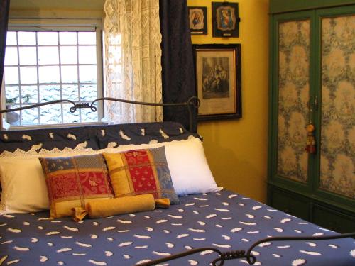 a bedroom with a bed with blue sheets and a window at Palazzo Minciotti Assisi in Assisi