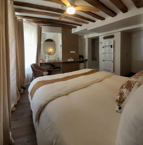 a bedroom with a large white bed in a room at Tresors de Sens in Sens