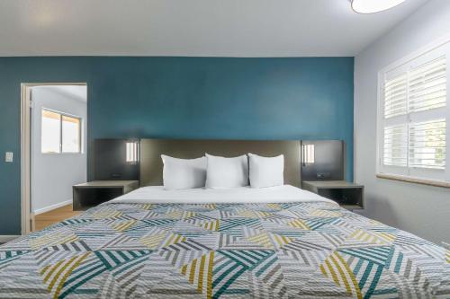 マデラにあるStudio 6 Suites Madera, CA Yosemiteの青い壁の大きなベッドのある寝室