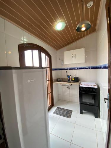 a small kitchen with a stove and a refrigerator at Suítes Cosfer in Saquarema