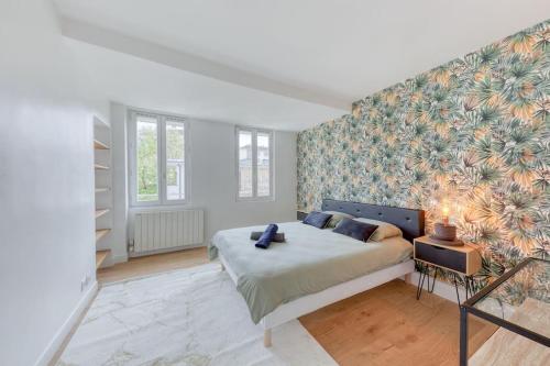 - une chambre avec un lit orné d'un mur fleuri dans l'établissement Le Spacieux Paris La défense, à Rueil-Malmaison