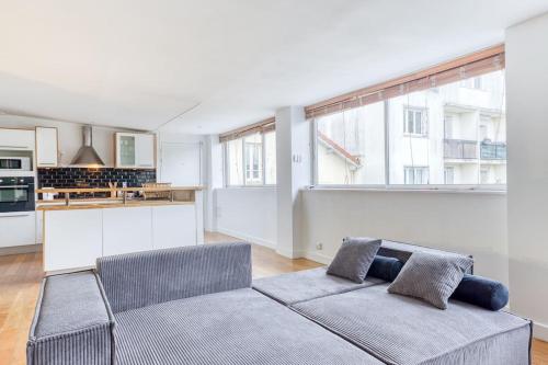 un salon avec un canapé et une cuisine dans l'établissement Le Spacieux Paris La défense, à Rueil-Malmaison