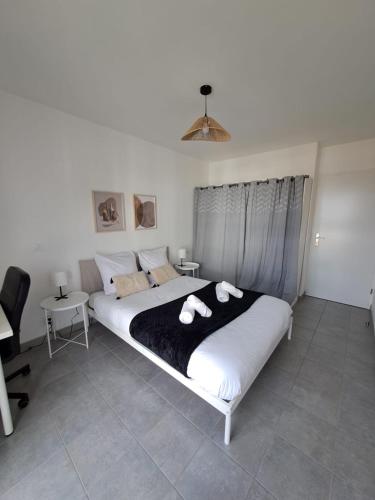 une chambre avec un grand lit avec des serviettes dessus dans l'établissement La Plaine St Denis, Paris Stade de France, à Saint-Denis